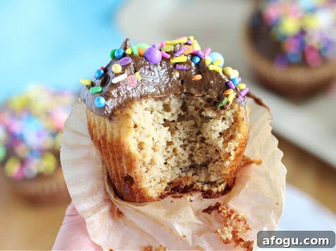 Vanilla cupcake with a bite out.