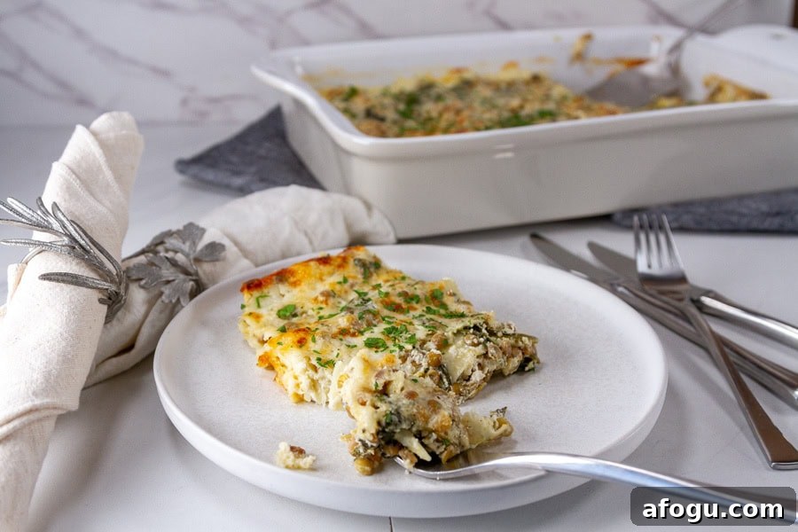 horizontal crop of a slice of lasagna in front of the casserole dish with some napkins and utensils around.