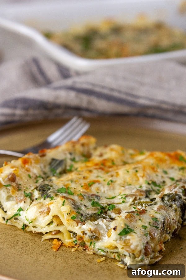 a slice of lasagna with a fork next to it on a brown plate.