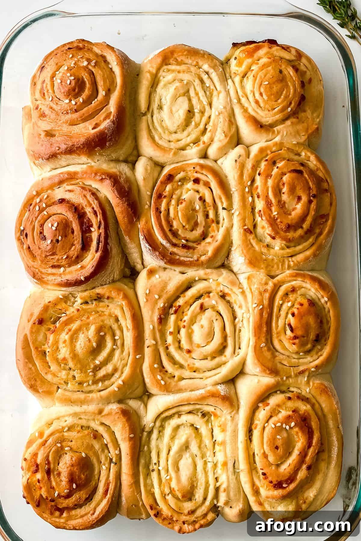 A glass baking dish filled with nine golden-brown, spiral-shapes arranged in a 3x3 grid.
