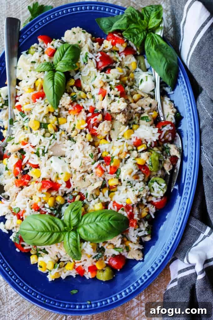 Italian Rice Salad with Tuna ready to serve Italian rice tuna salad on a blue plate with kitchen towel on a side