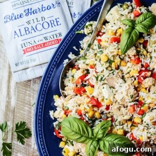 Italian Rice Salad with Tuna on a blue plate with tuna pouches on a side