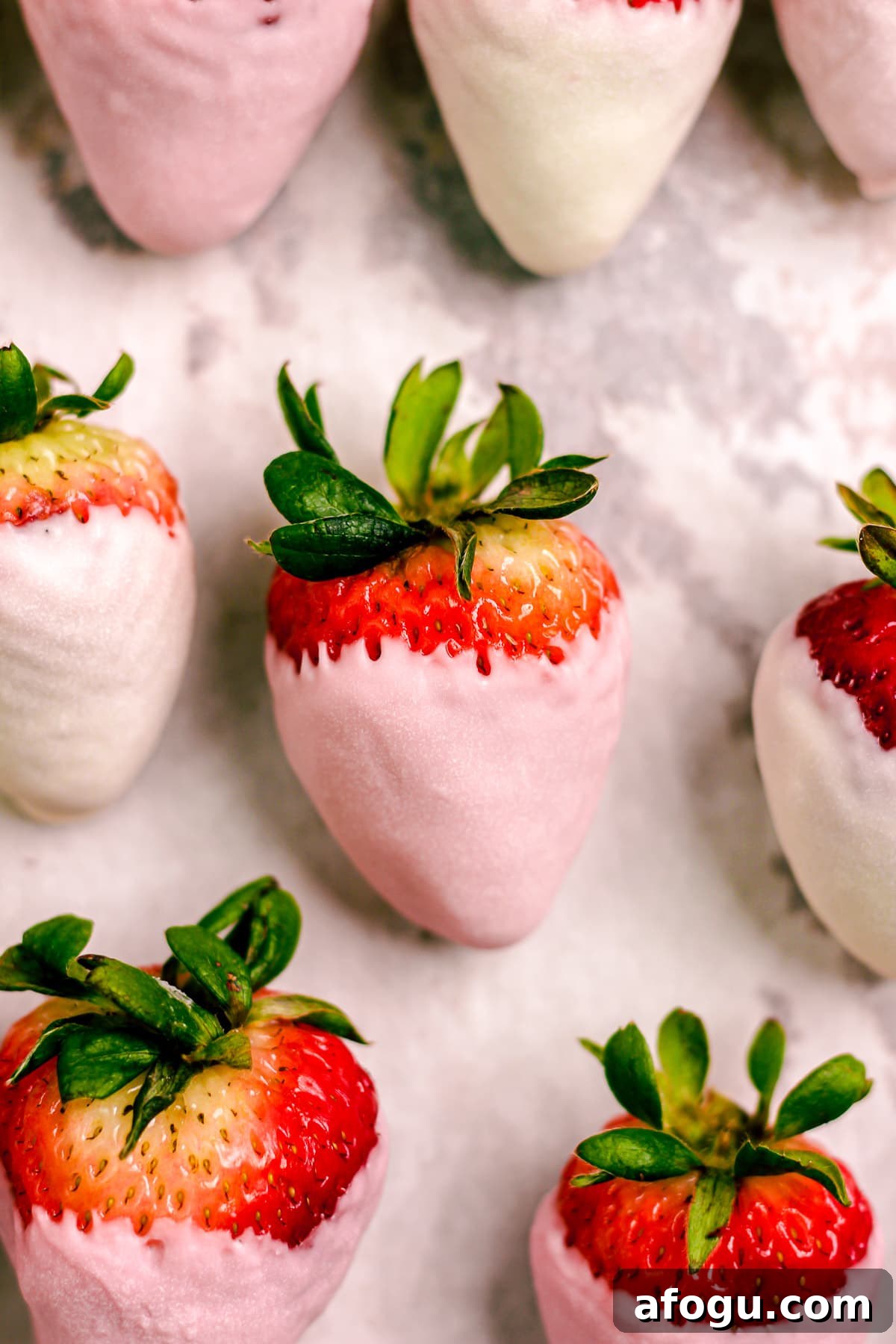 Pink chocolate strawberries arranged on a tray