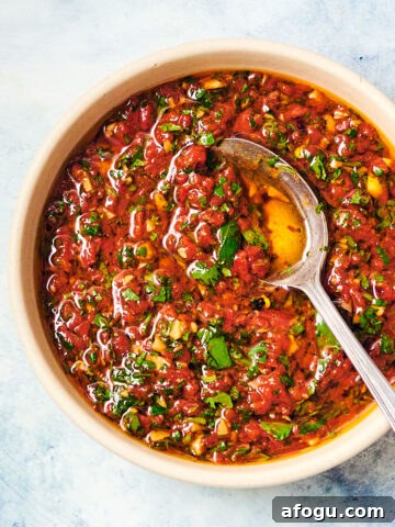 Red Chimichurri (Chimichurri Rojo) in a bowl with a spoon.