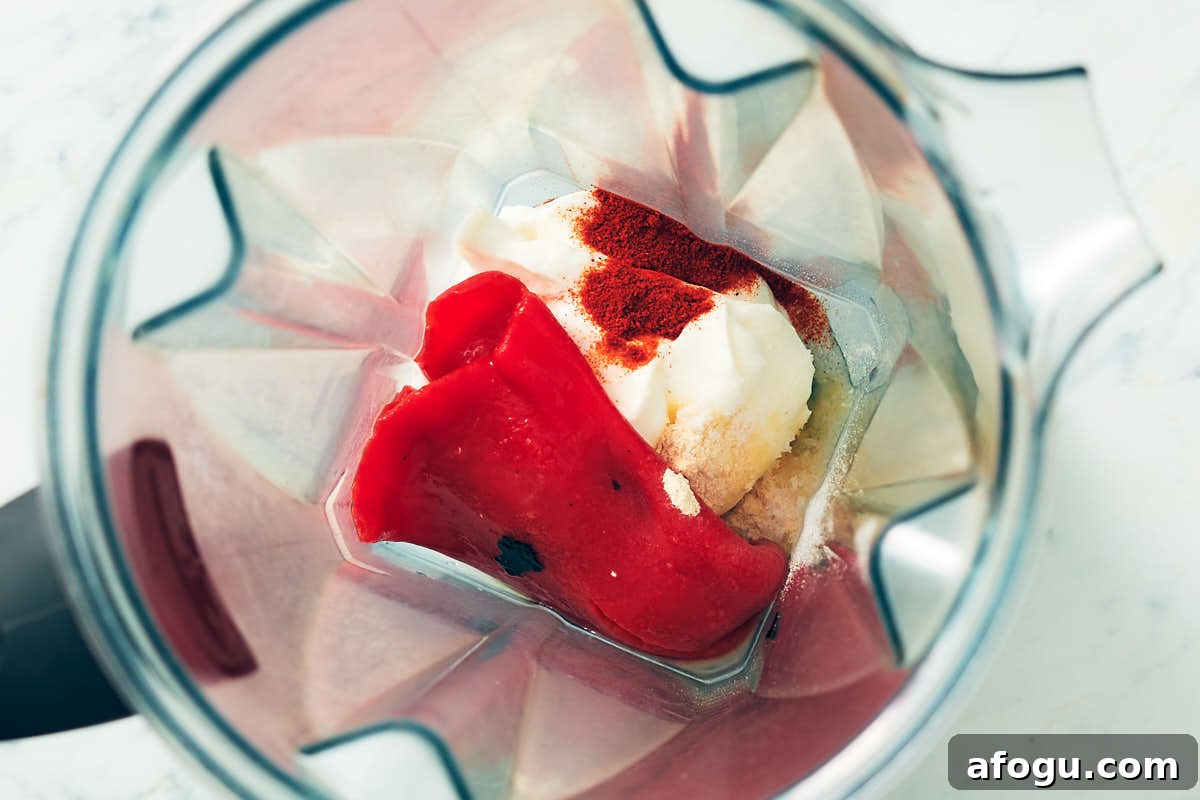 Sour cream, roasted red pepper, lime juice, and spices in a blender container.