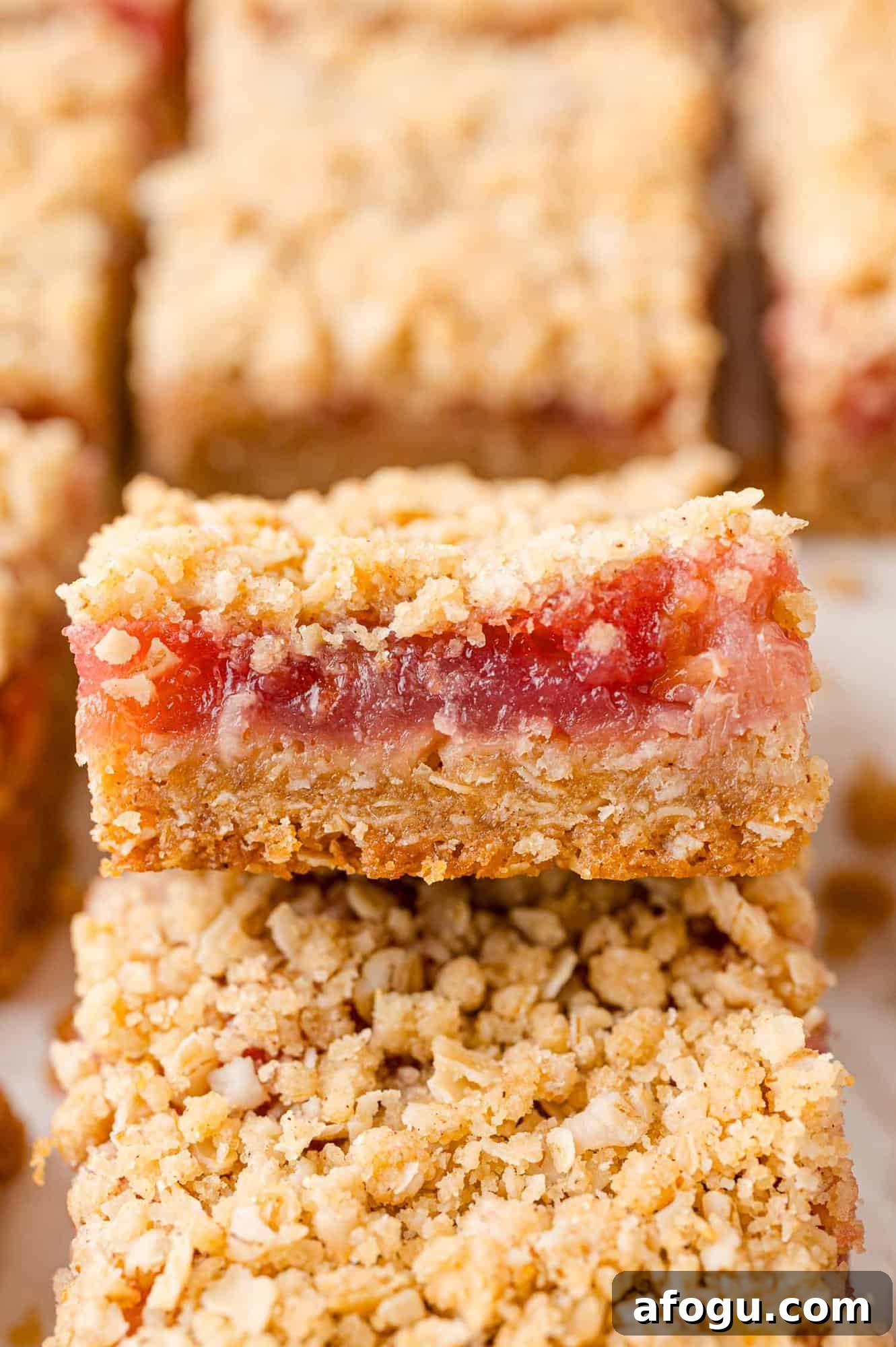 Rhubarb bars, with crumb topping, stacked on each other.