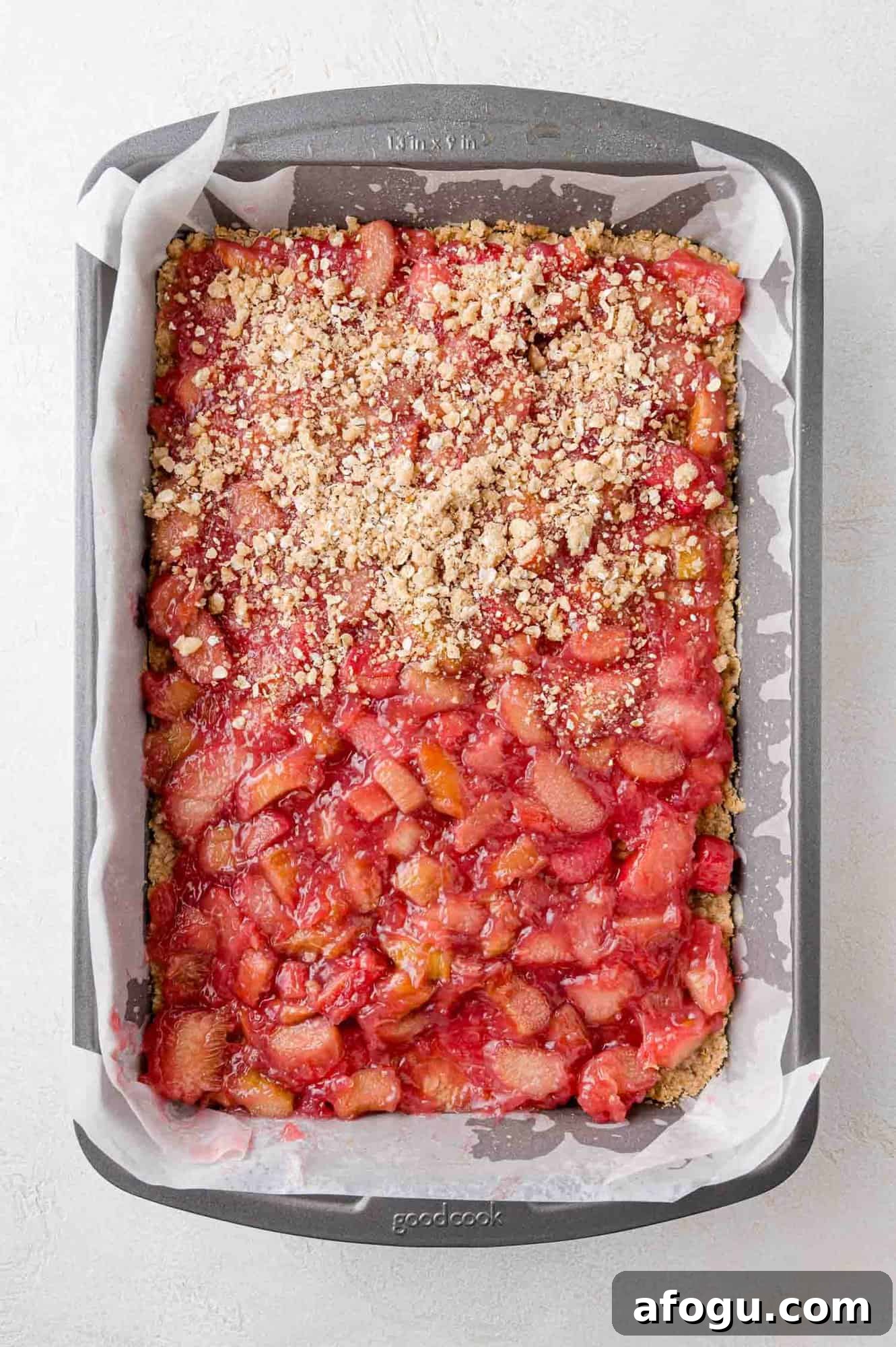 Top crumb crust being added on top of rhubarb filling.