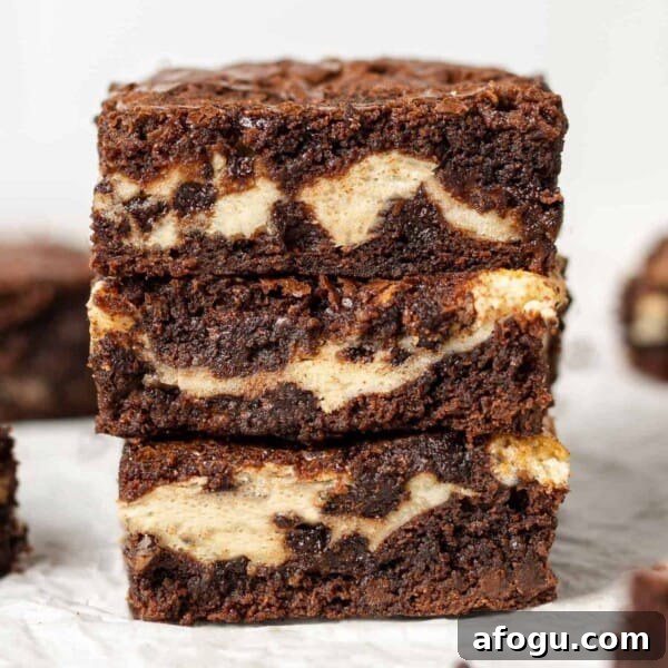 Stack of three cream cheese filled brownies.