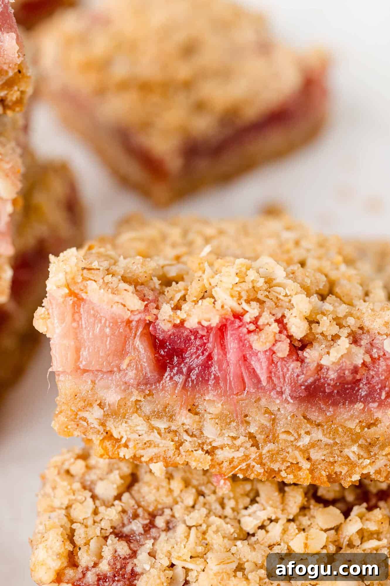 Crumb topped rhubarb bar, with a bite taken from it.