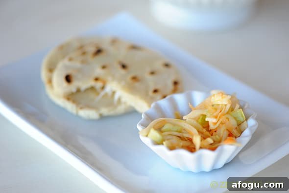 pupusas on a plate with a side of curtido