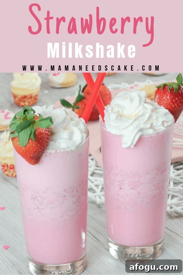 Strawberry milkshake in tall glass with whipped cream and fresh strawberry garnish.