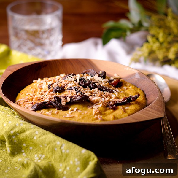 A bowl of Curried Roasted Cauliflower Soup with Crispy Fried Mushrooms and toasted coconut sprinkled over the top.