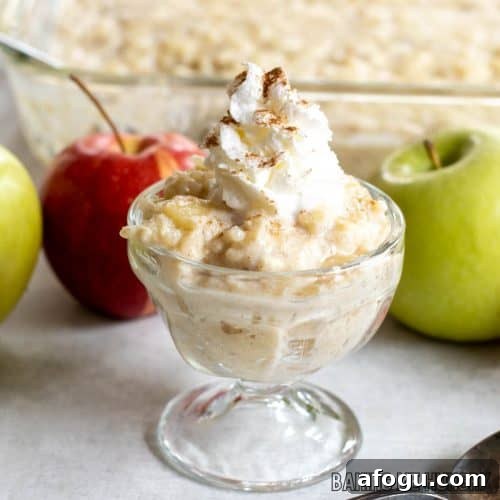 rice pudding with apples topped with whipped cream and cinnamon in small glass dish