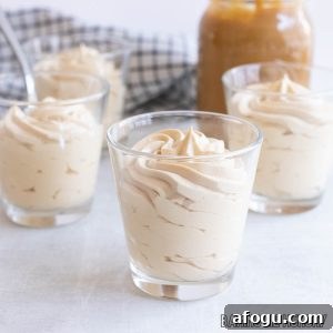 caramel mousse in small glasses with a jar of dulce de leche caramel sauce behind