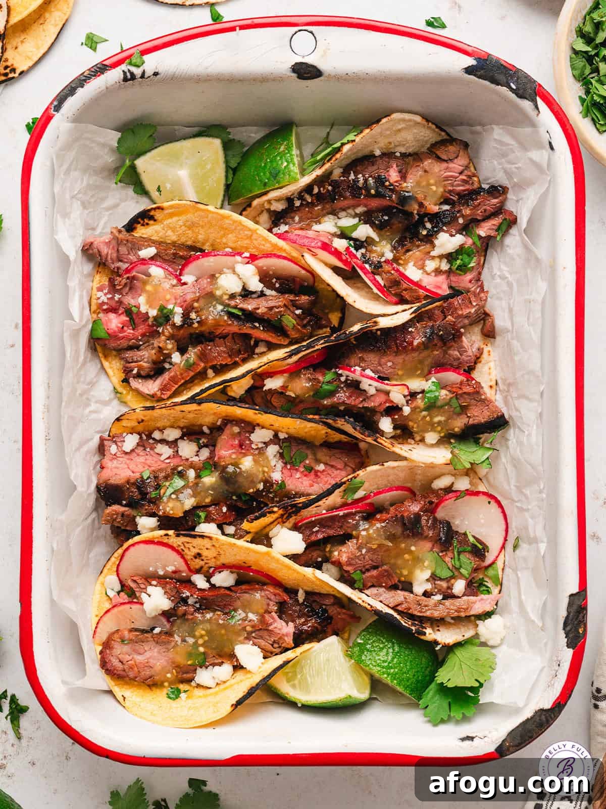 These vibrant Baja Steak Tacos are loaded with zippy marinaded grilled skirt steak and topped with cotija cheese, radishes, and cilantro. Overhead image of Baja street tacos.