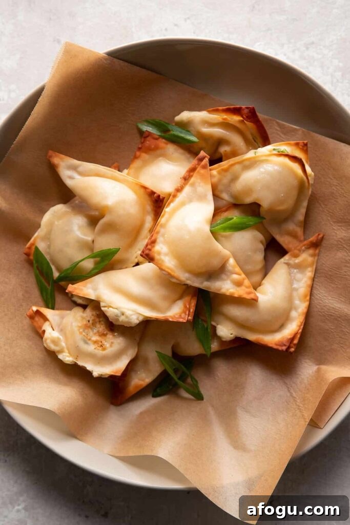 Crispy Baked Cream Cheese Wontons Recipe 4 cream cheese wontons in a bowl with green onions on top