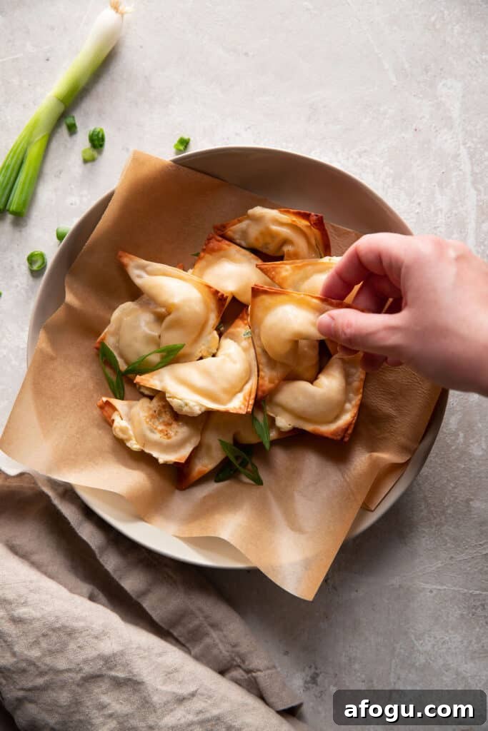 Crispy Baked Cream Cheese Wontons Recipe 8 cream cheese wontons in a bowl with green onions on top
