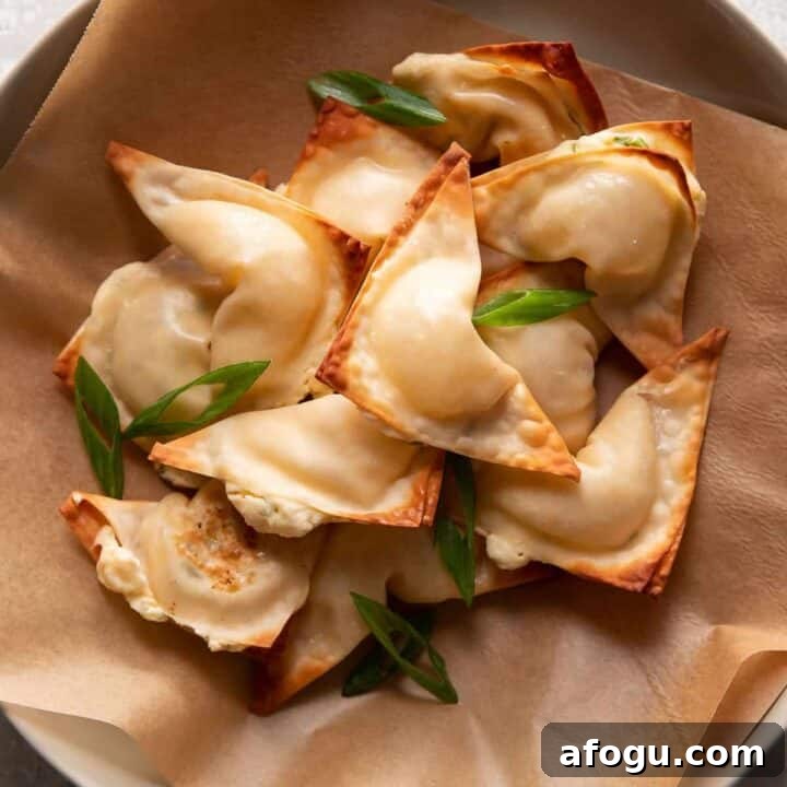 cream cheese wontons in a bowl with green onions on top