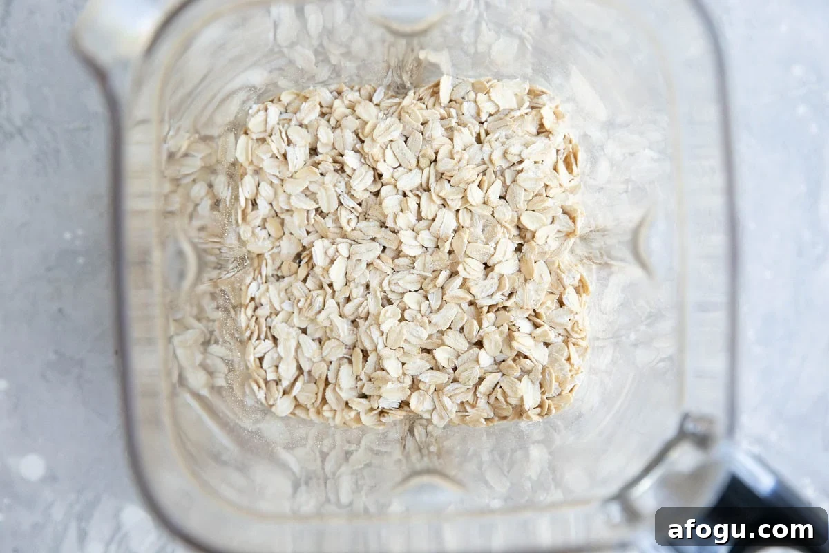 Rolled oats in a blender, ready to be blended into a flour.