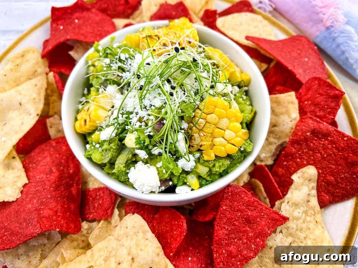 Corn guacamole with tortilla chips on a plate.
