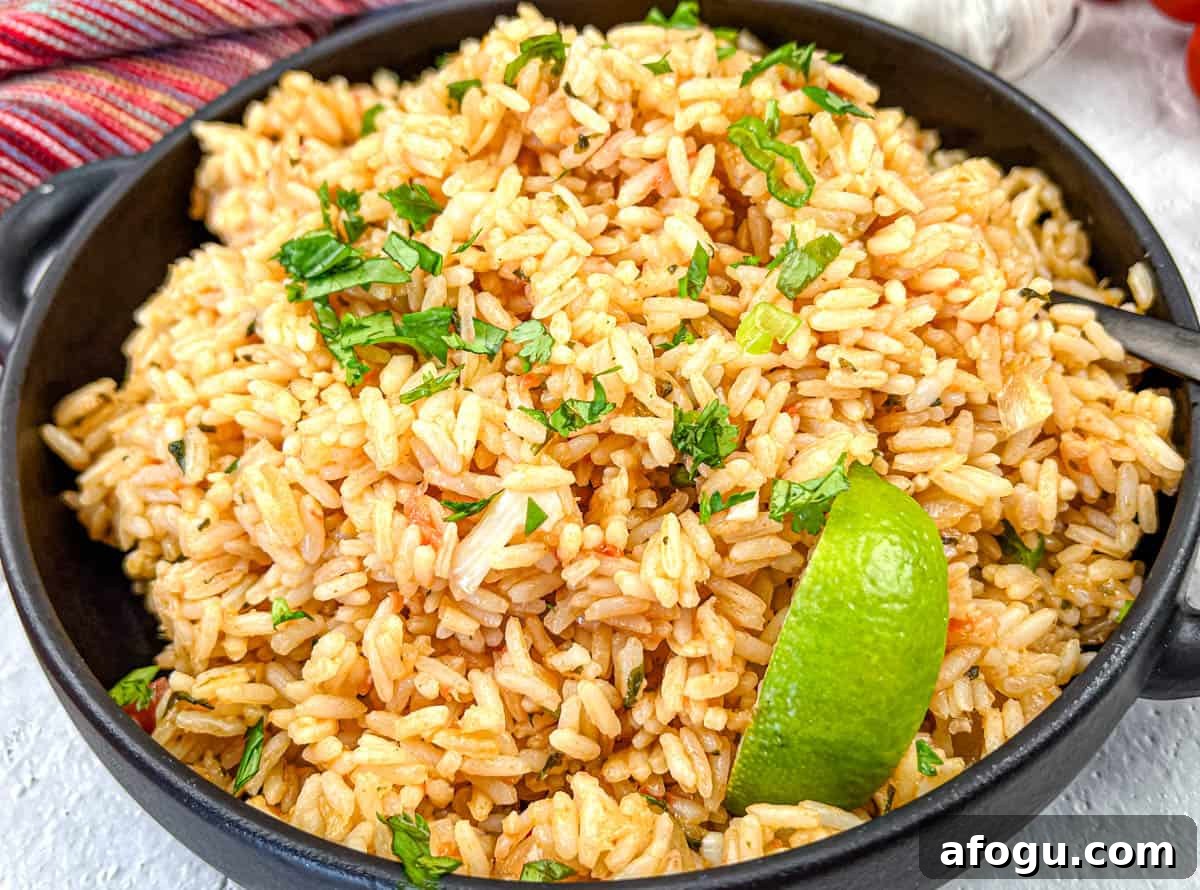 Mexican Rice with a slice of lime on a black bowl.