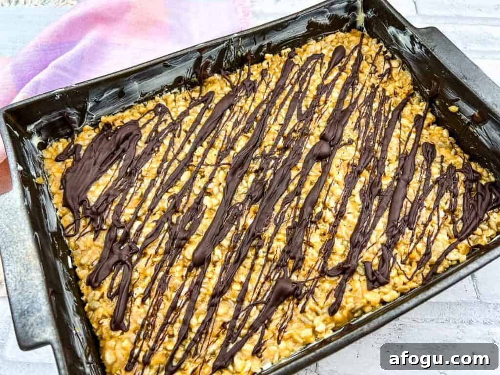 A rectangular baking pan filled with molly bars and melted chocolate drizzle.