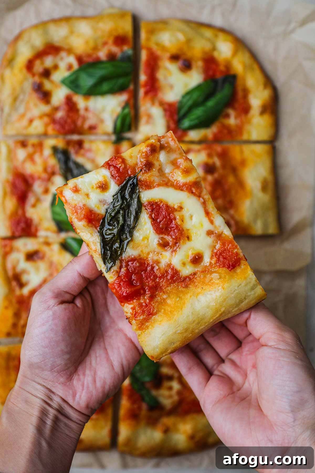 Homemade Margherita Pizza Recipe: Classic Neapolitan Flavor at Home 6 Hand holding a slice of homemade margherita pizza.