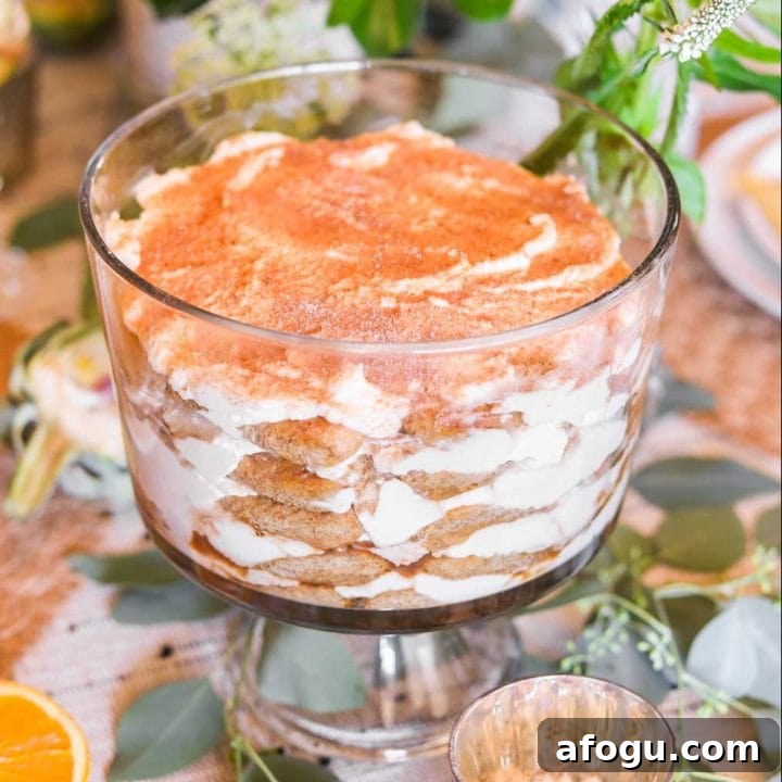 Tiramisu in a glass trifle bowl with green and white flowers