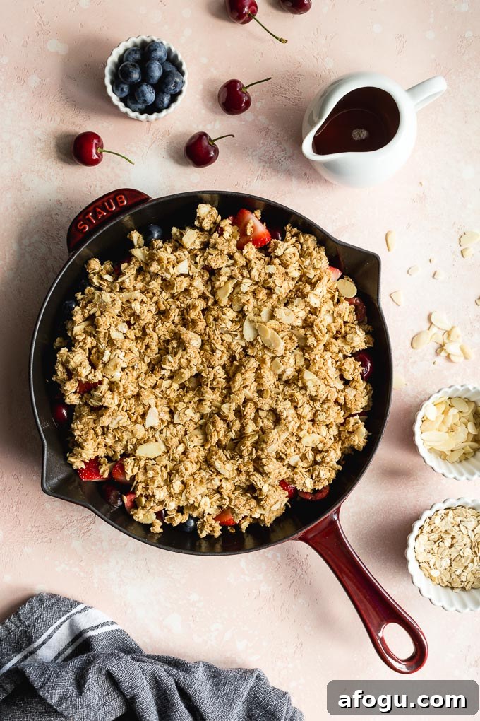 Gluten-free cherry crisp assembled in a cast iron skillet.