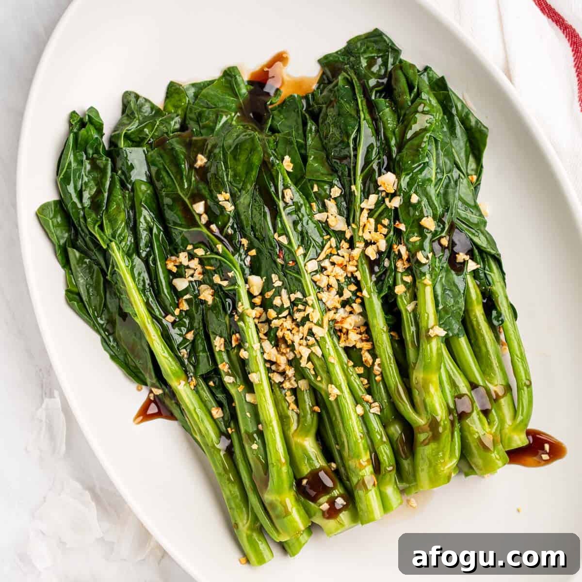 Plate of stir fried Chinese Broccoli with oyster sauce and fried garlic.