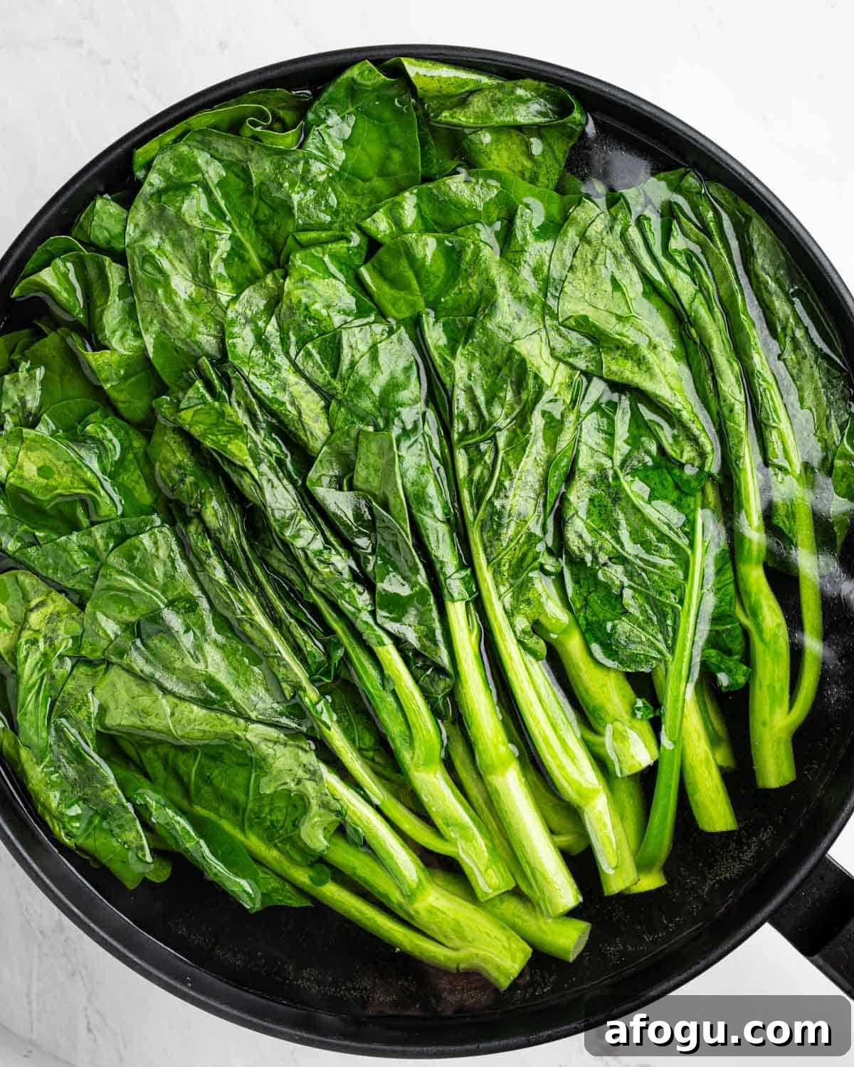 Boiling Chinese broccoli in wok.