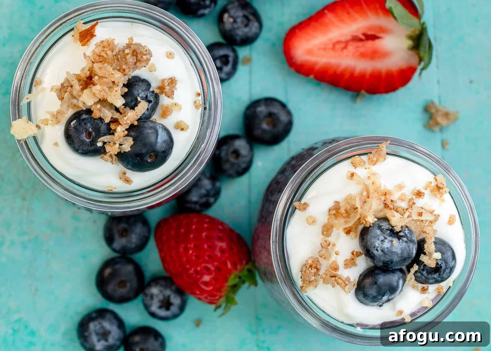 overhead shot showing two blueberry chia pudding parfaits topped with blueberries and granola