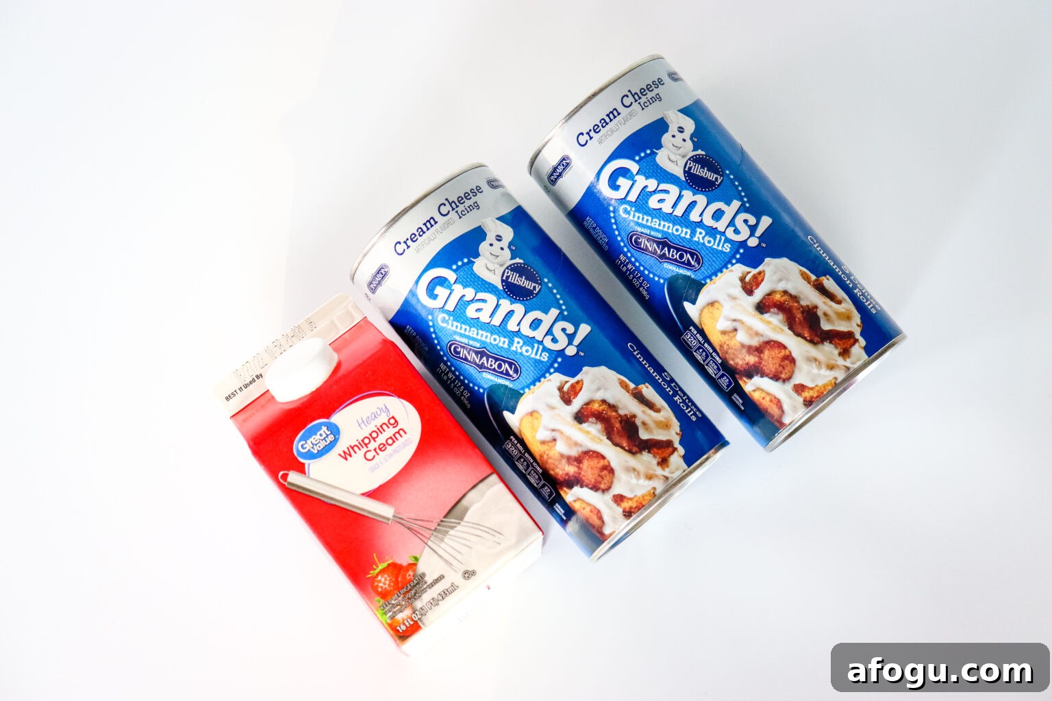 cinnamon roll containers and heavy whipping cream ingredients on white table