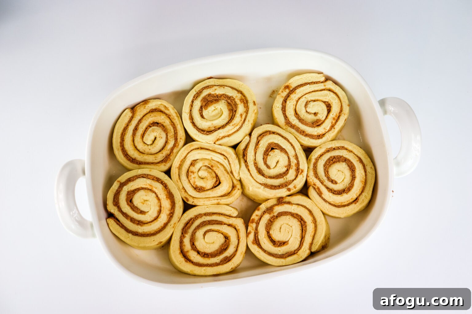 raw cinnamon rolls placed into baking dish