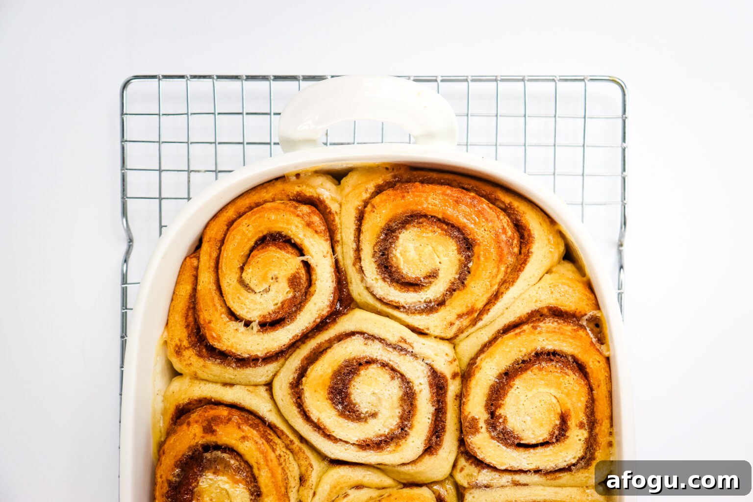 cooked cinnamon rolls in white pan