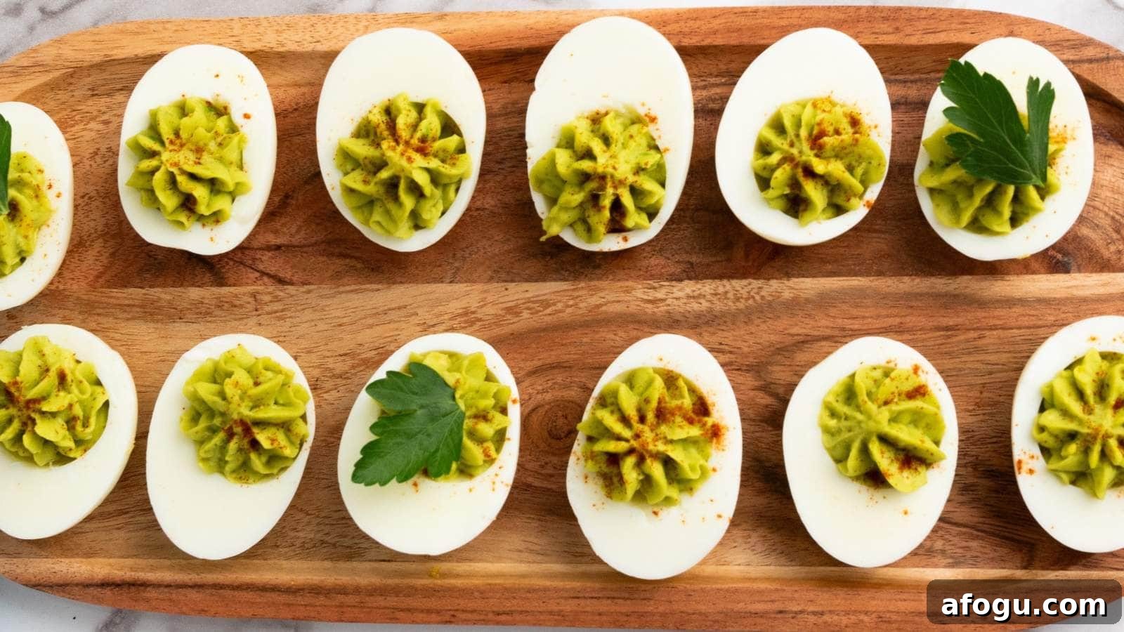 Deviled eggs topped with green filling and paprika are arranged on a wooden serving tray, garnished with parsley leaves.