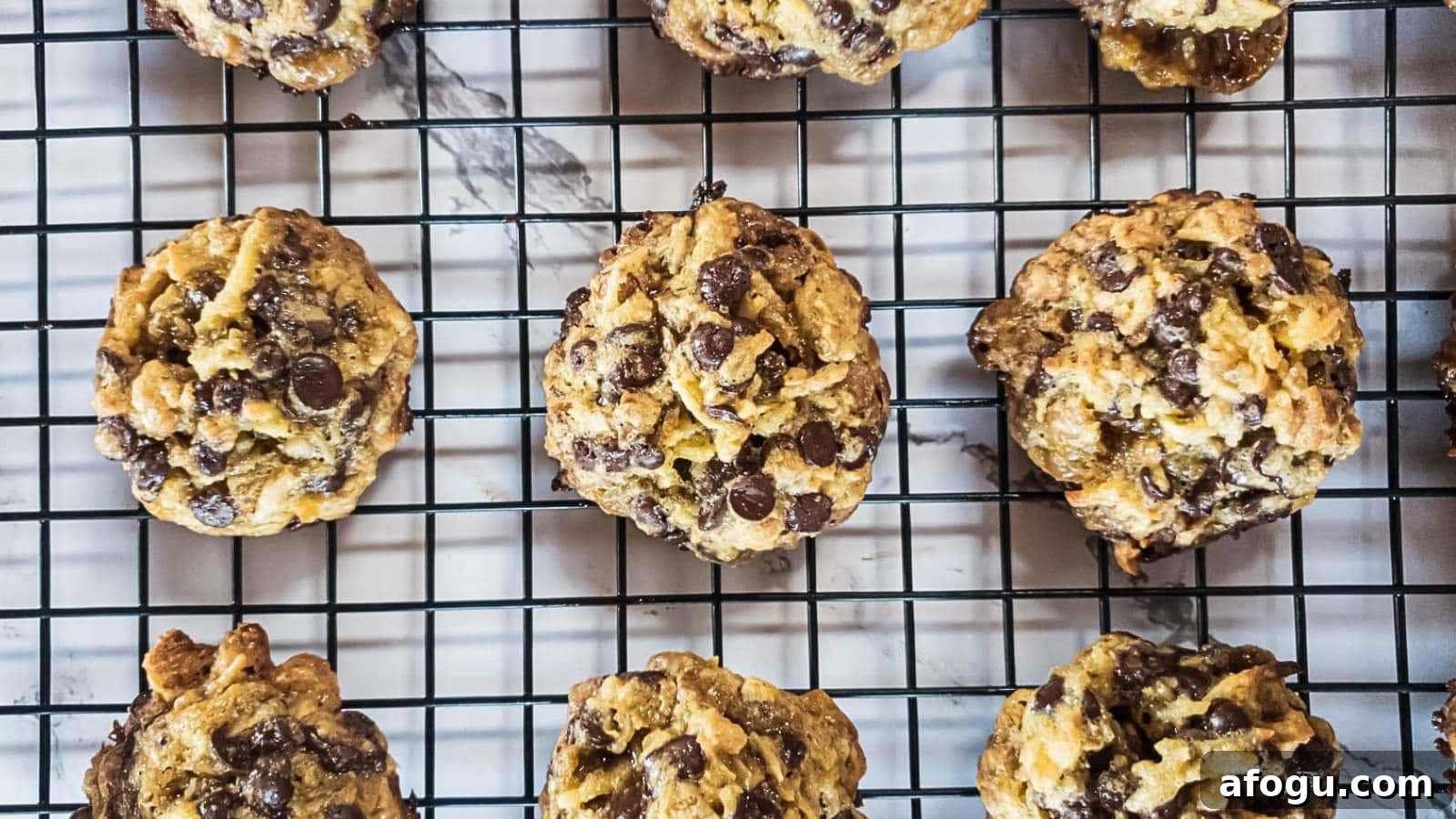 Keto magic cookies cooling on a black wire rack over a marble surface.