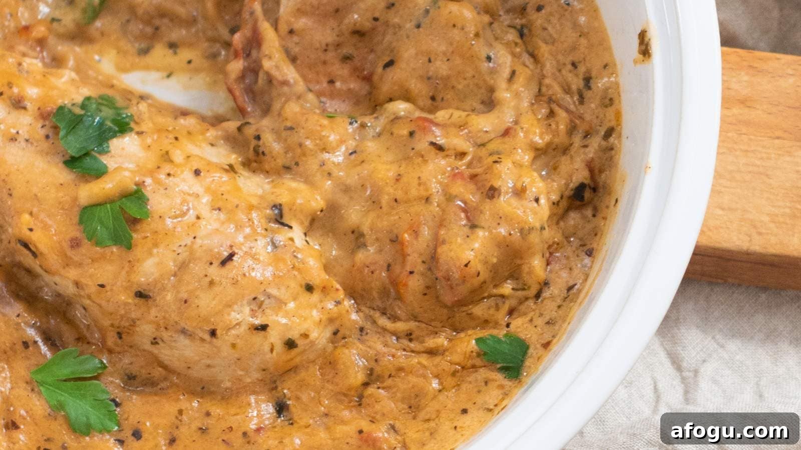 Close-up of marry me chicken garnished with parsley.