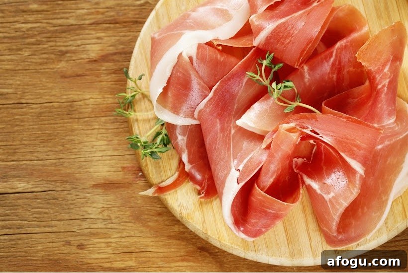 very thin slices of ham on a round wooden cutting board.