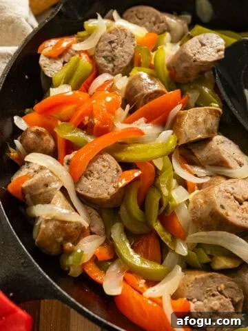 Grilled sausage and peppers in a cast iron pan.