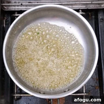 Simmering butter and garlic with lemon in a pot.