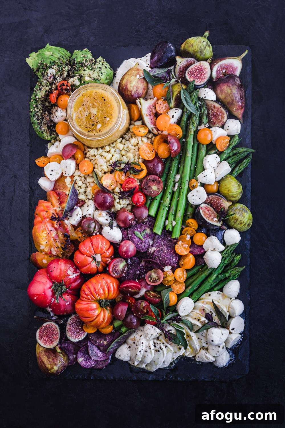 Summer Salad Recipe That Keeps Giving All Season Long 3 Summer salad board filled with seasonal summer fruit and veggies, overhead shot on a black background.