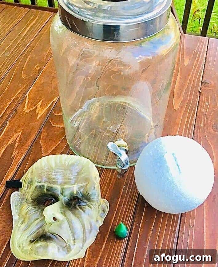 Large jar, styrofoam ball, mask, and food coloring.