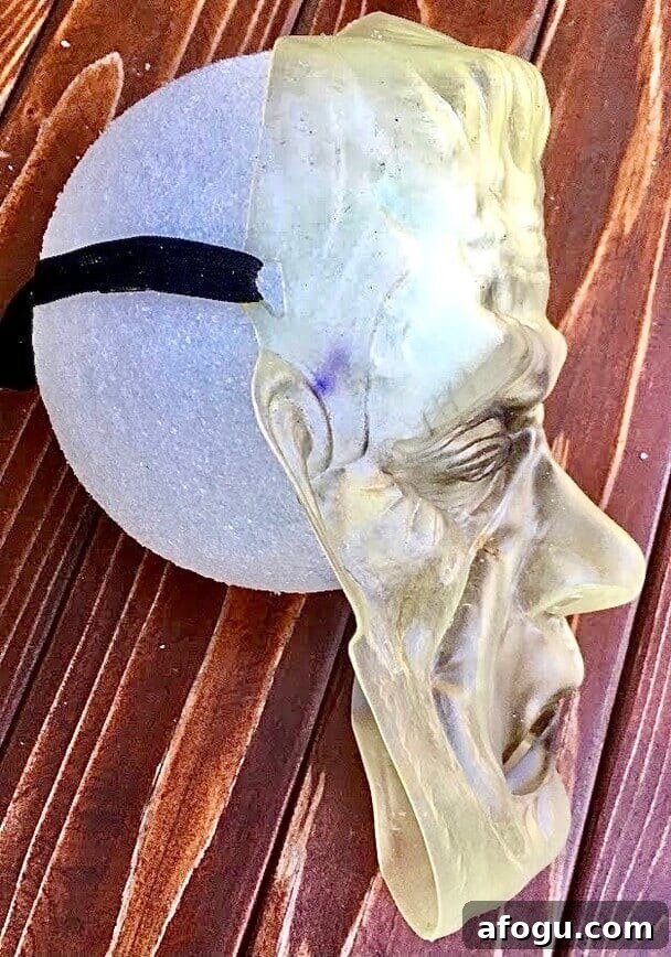 Attach mask to styrofoam ball.