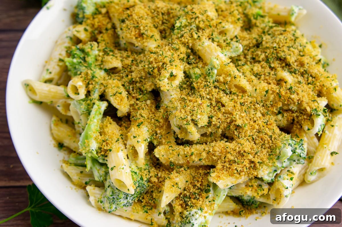 a bowl of penne and broccoli topped with herbed toasted breadcrumbs.