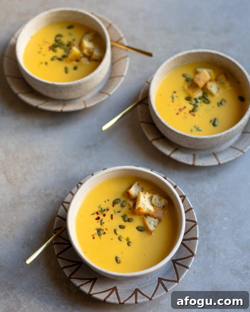 Overhead view of 3 bowls of creamy pumpkin soup