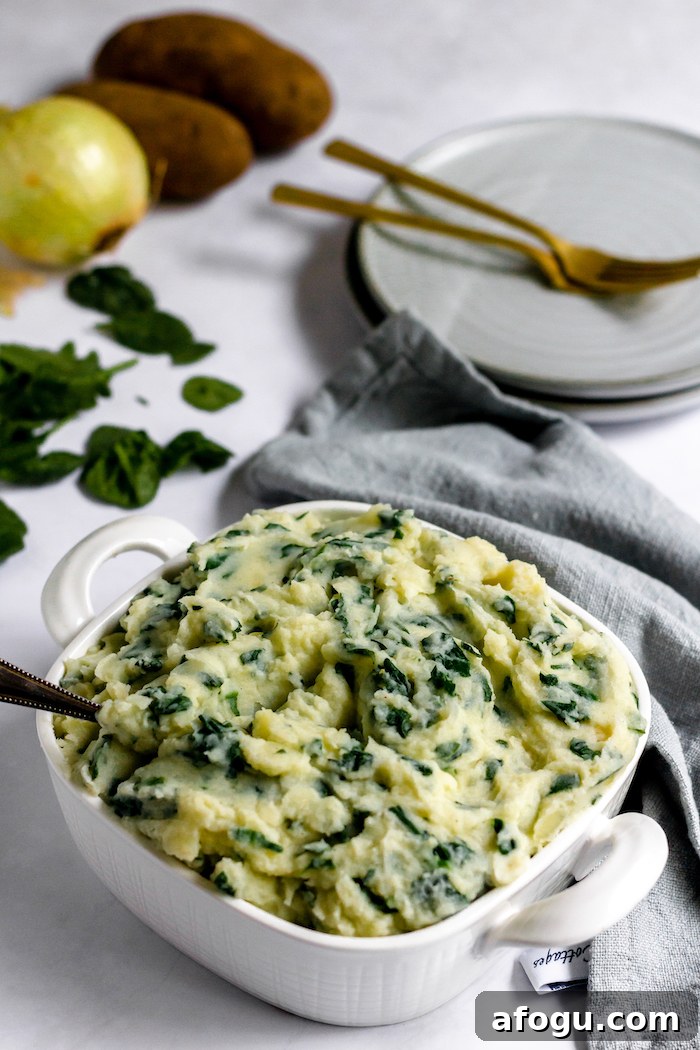 Image shows a dish of spinach and mashed potatoes on a table