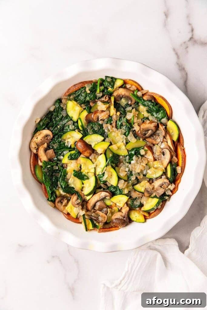 sauted mushrooms, onions, zucchini and spinach in pie pan