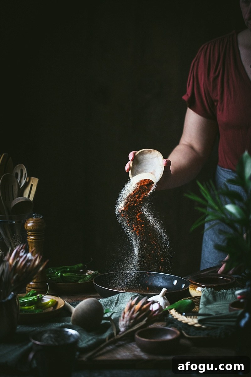 woman pours garlic and chili powder in for easy mole sauce