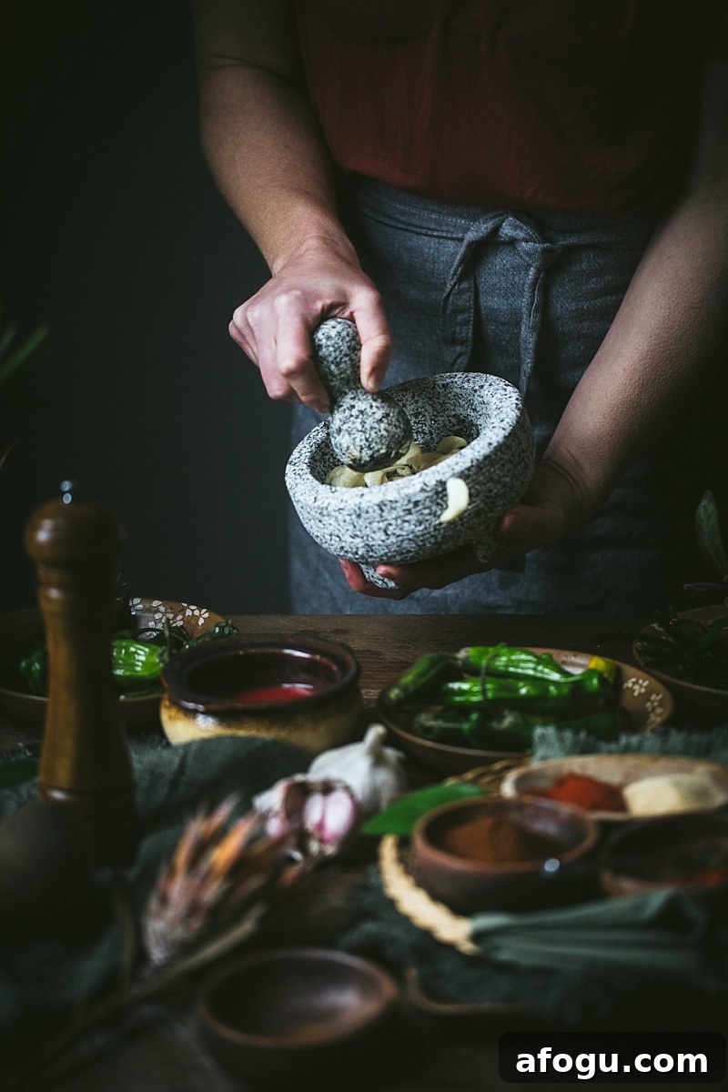 woman crushes garlic in molcajete